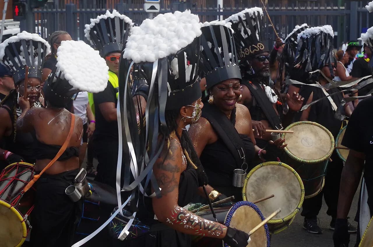 Tambourinaires en costume noir et coiffes à ruban lors d'un vidé du carnaval de Martinique