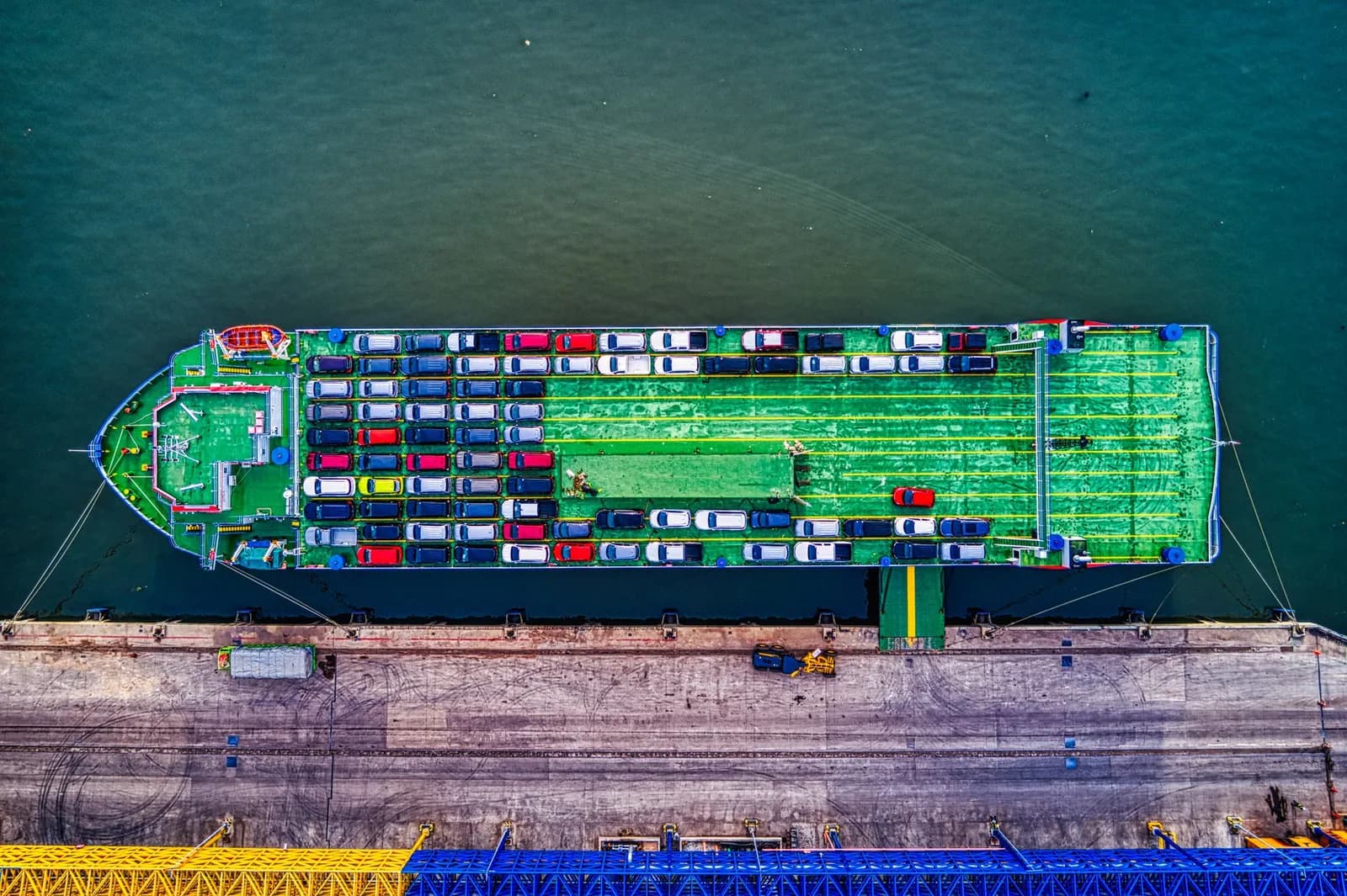 Vue aérienne d'un navire roulier chargé de voitures, amarré le long d'un quai portuaire