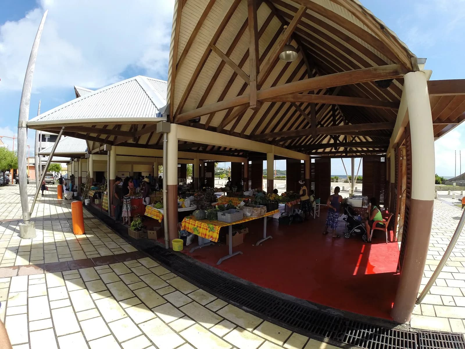 Halle du marché couvert du Vauclin avec étals de fruits et légumes locaux sous une charpente en bois