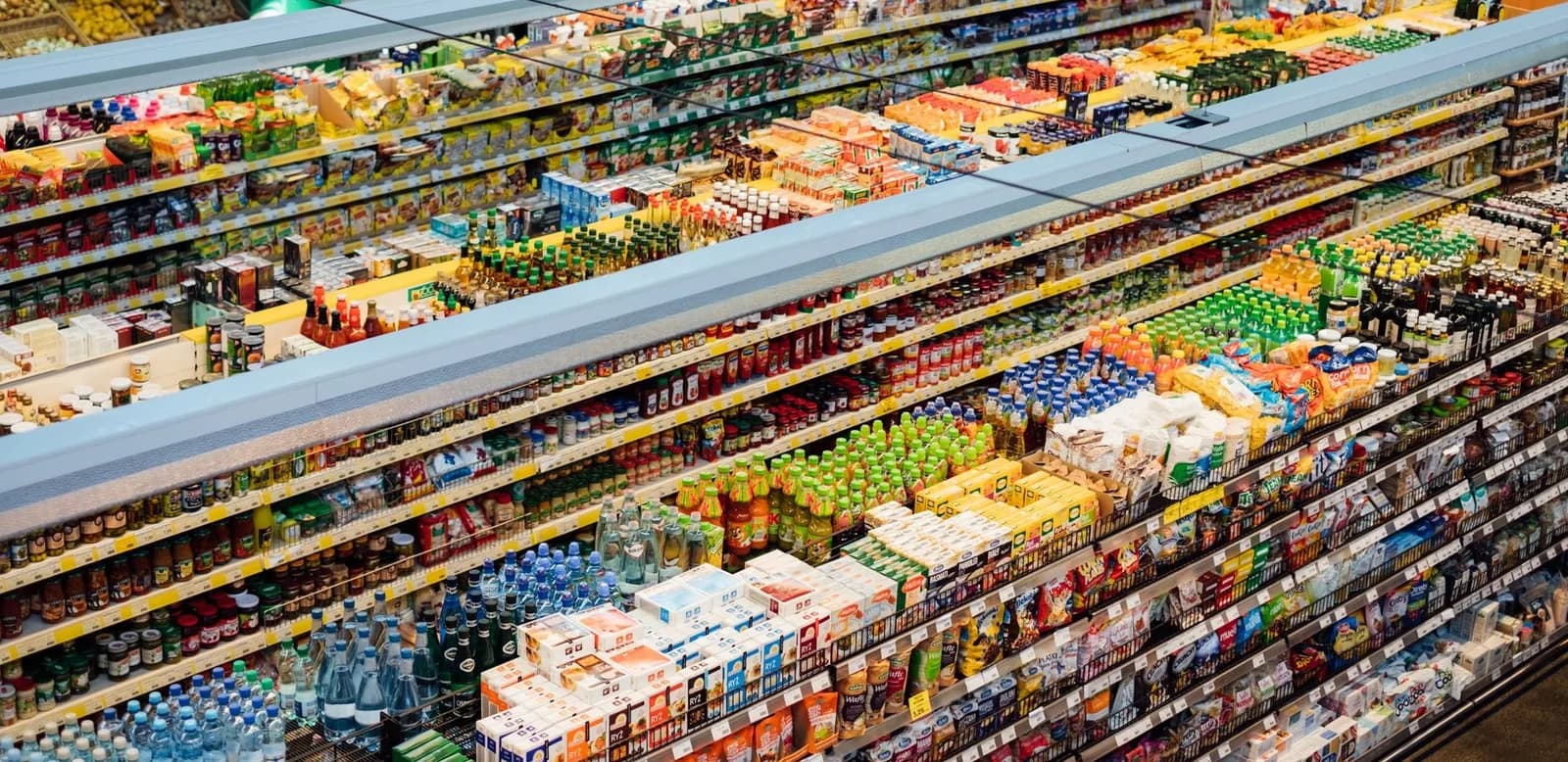 Rayons d'un supermarché garnis de produits alimentaires, boissons et conserves vus de dessus