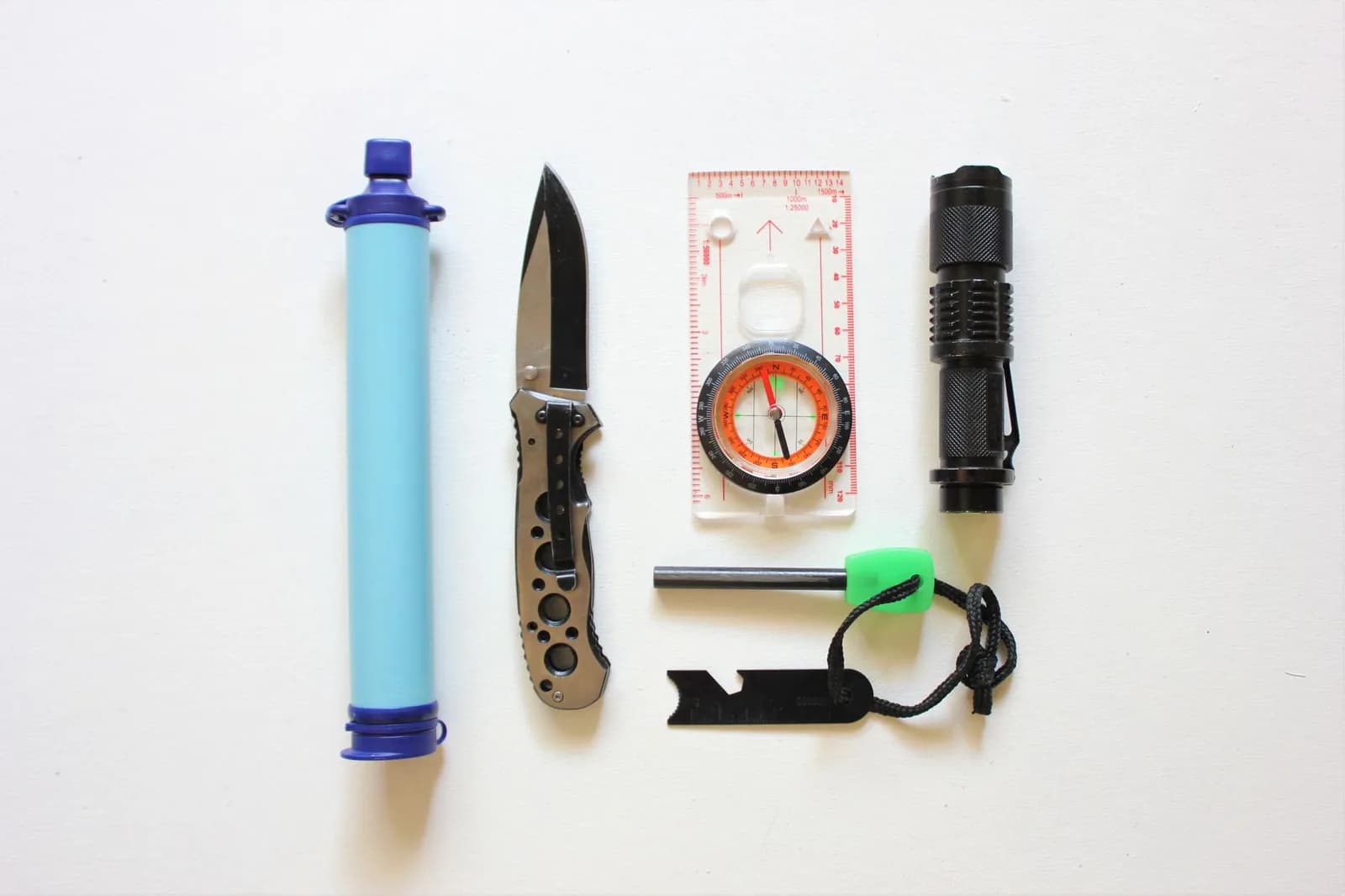 Équipement d'urgence : lampe torche, filtre à eau, boussole, couteau et briquet à silex