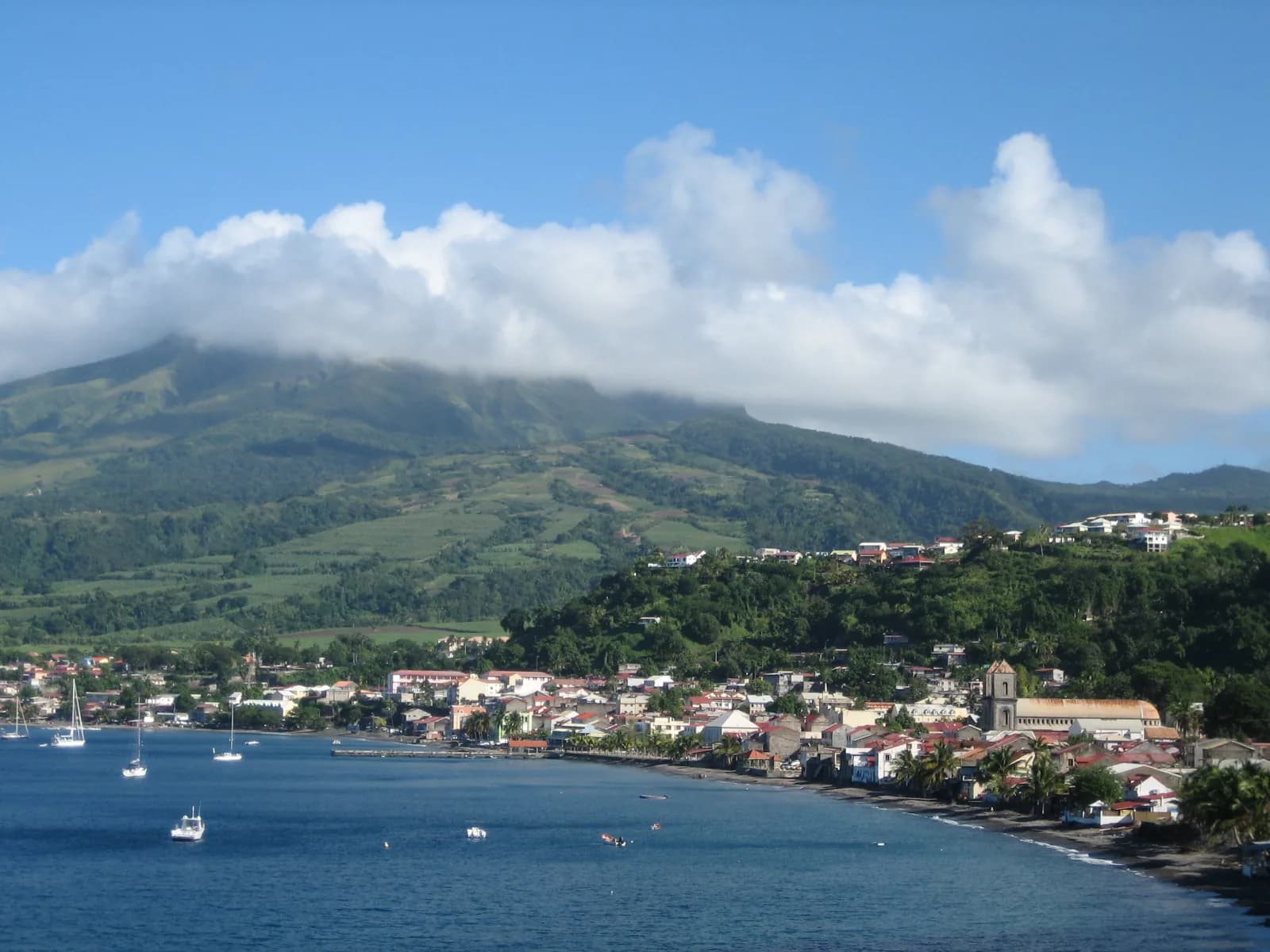La Montagne Pelée en partie coiffée de nuages, au-dessus de la baie et de la ville de Saint-Pierre