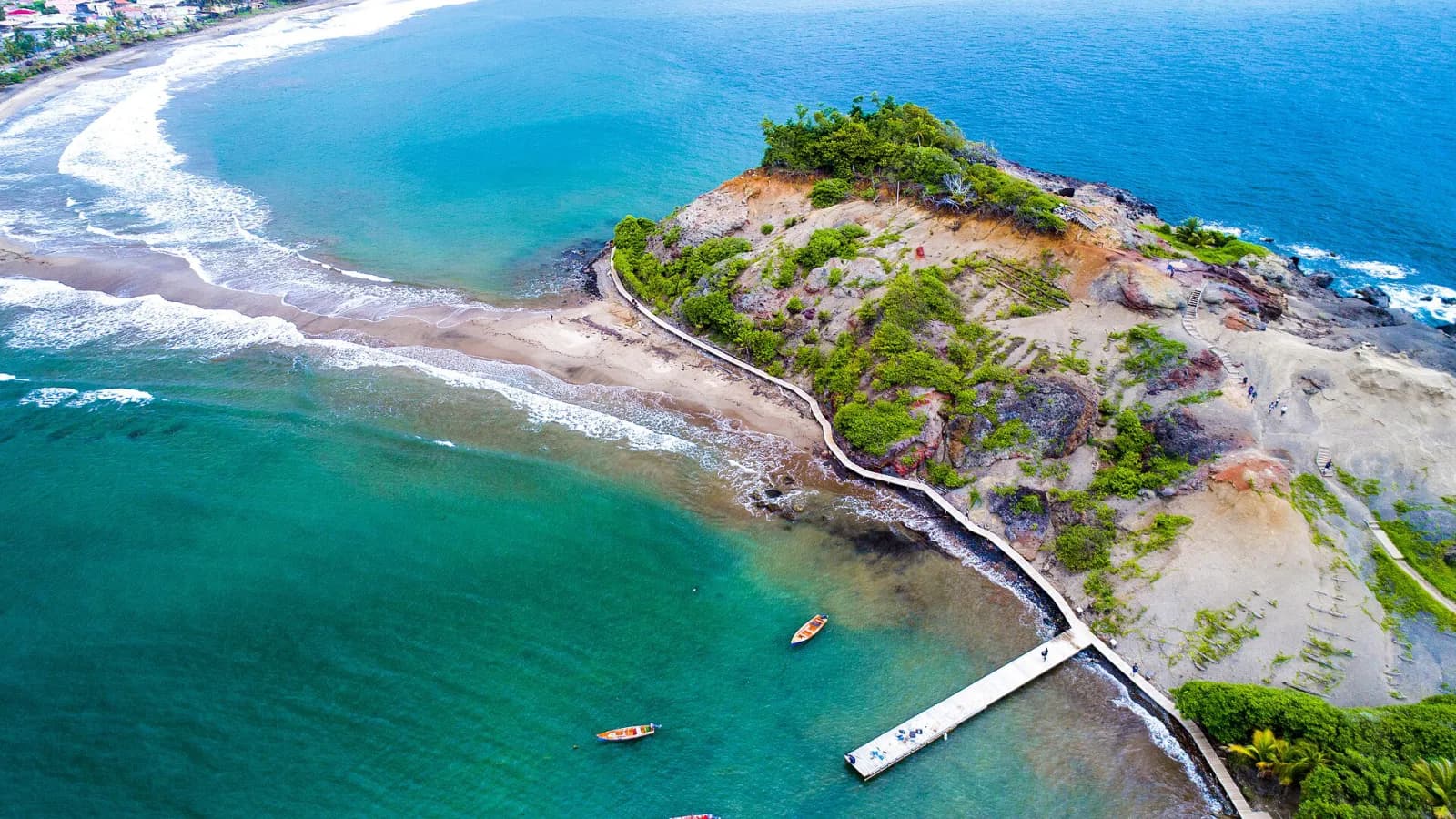 Vue aérienne du tombolo de Sainte-Marie : langue de sable reliant la côte à l'îlet boisé, entre mer turquoise et bleu profond