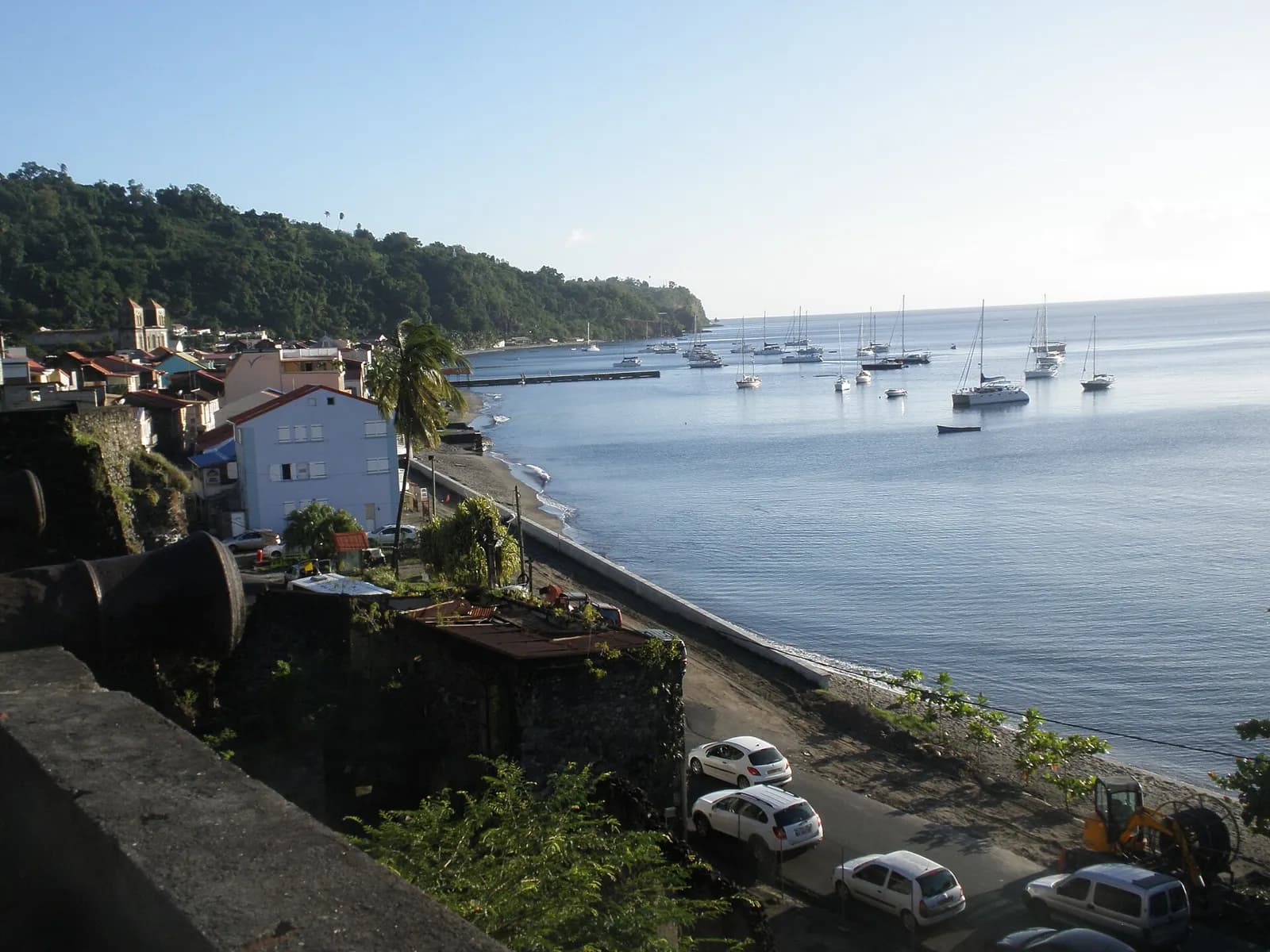 Rade de Saint-Pierre vue depuis les remparts, avec voiliers au mouillage et rivage de sable sombre