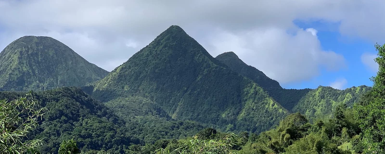 Les Pitons du Carbet, sommets pointus couverts de forêt tropicale sous un ciel nuageux, Martinique
