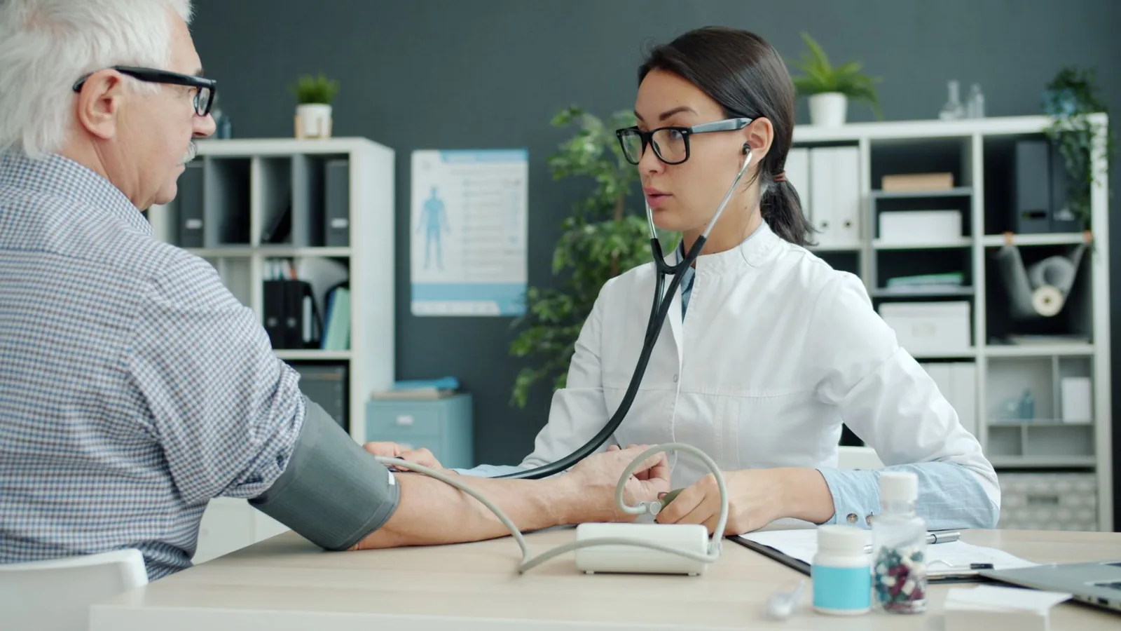 Médecin prenant la tension d'un patient âgé lors d'une consultation