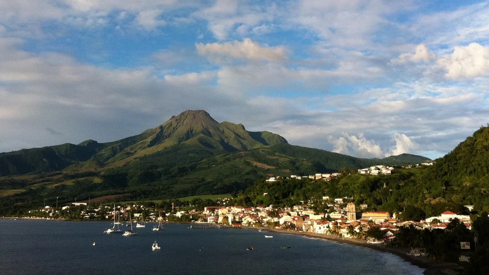 La montagne Pelée dominant la rade et la ville de Saint-Pierre, en Martinique, au soleil couchant