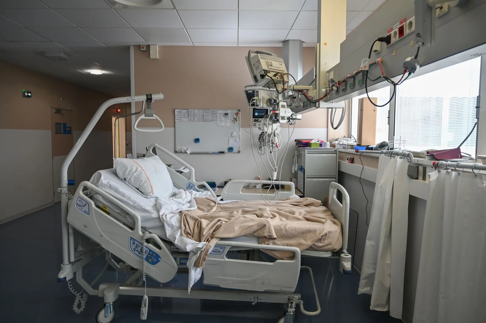 Chambre d'hôpital avec lit médicalisé et équipements de surveillance