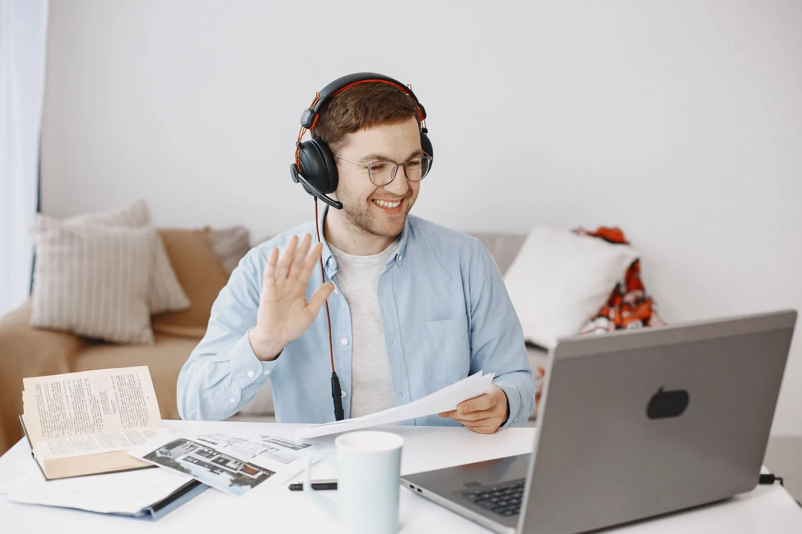 Homme souriant avec un casque en visioconférence sur son ordinateur portable