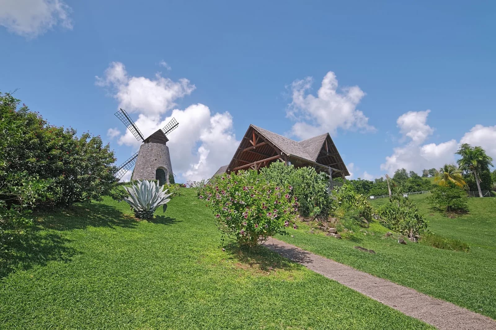 Moulin à vent en pierre et bâtiment de la plantation Trois-Rivières dans les pelouses du domaine, Sainte-Luce, Martinique