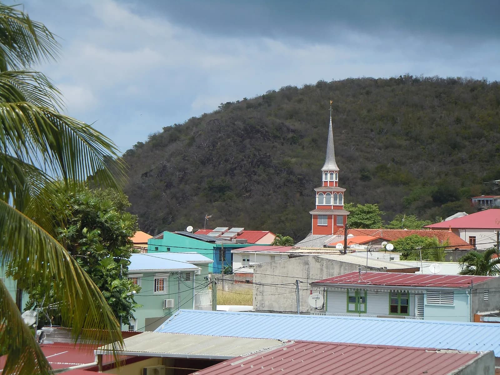 Clocher et toits colorés du bourg des Anses-d'Arlet au pied d'un morne